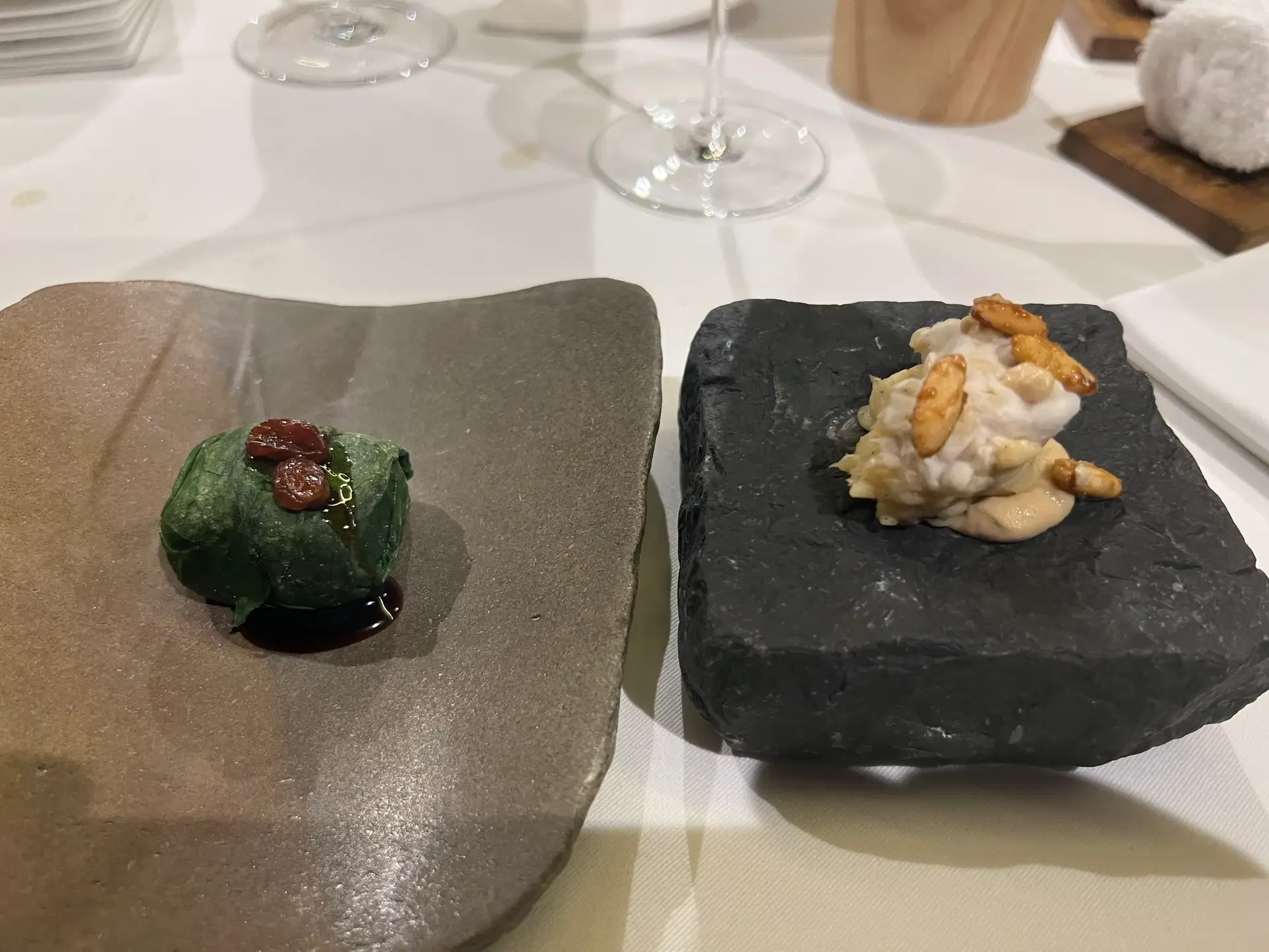 A dense grey sculptural course on a cream plate at Mugaritz