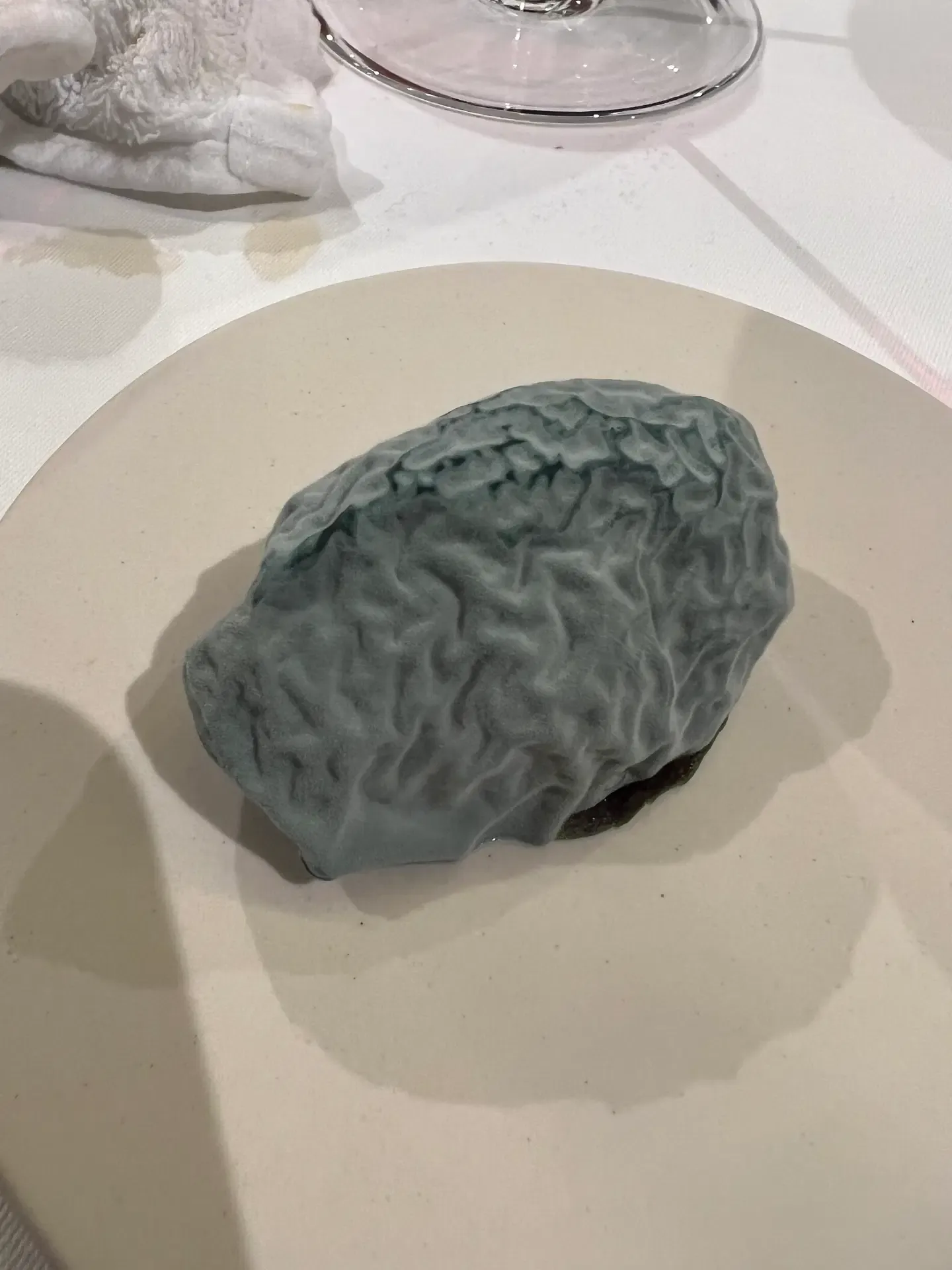 A pale green bite paired with a small white cream at Mugaritz